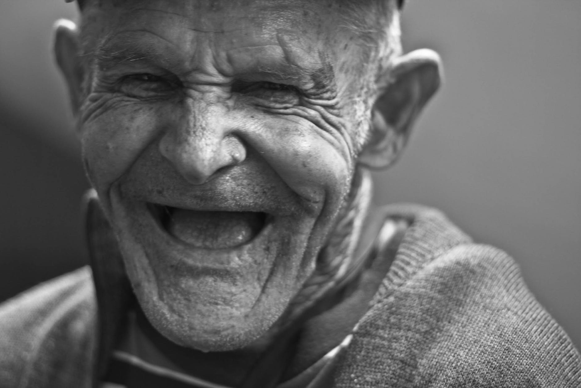 grayscale photo of laughing old man